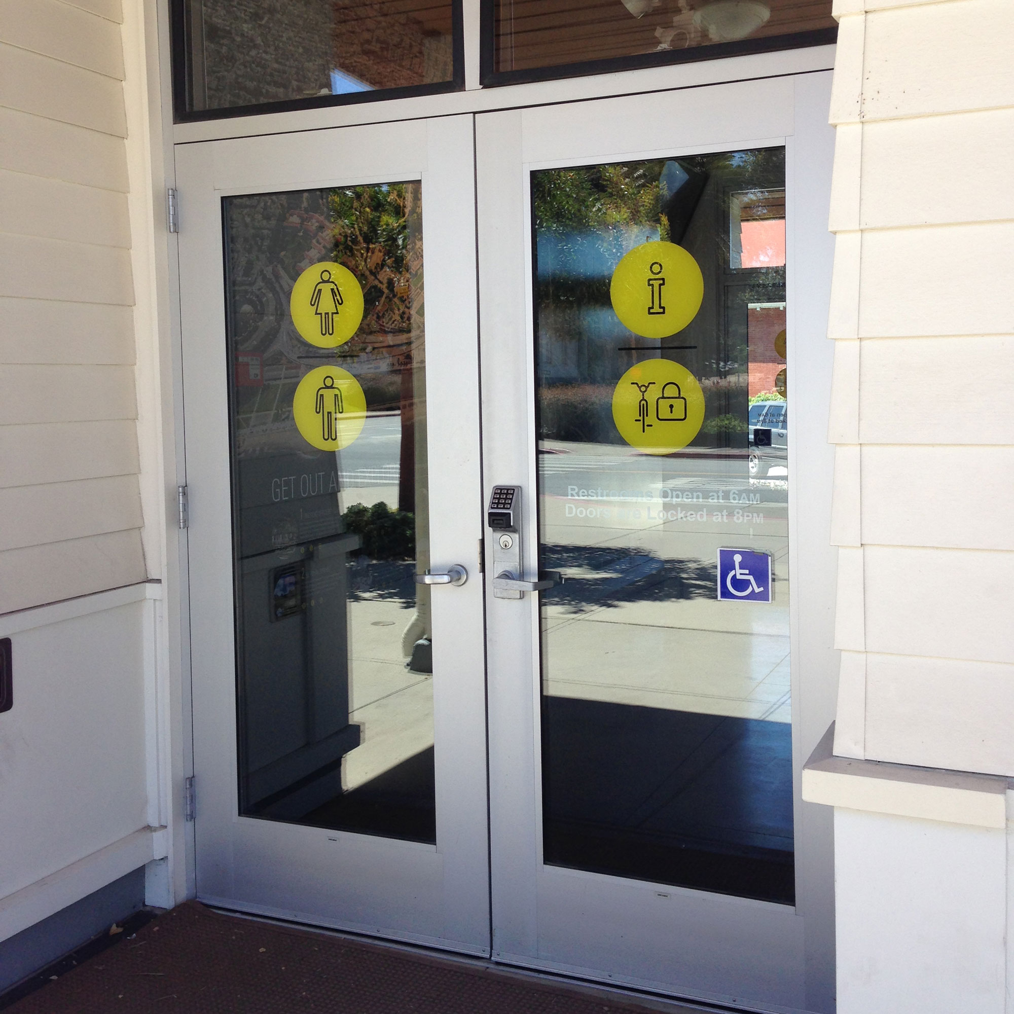 Wayfinding icons on glass entry doors.