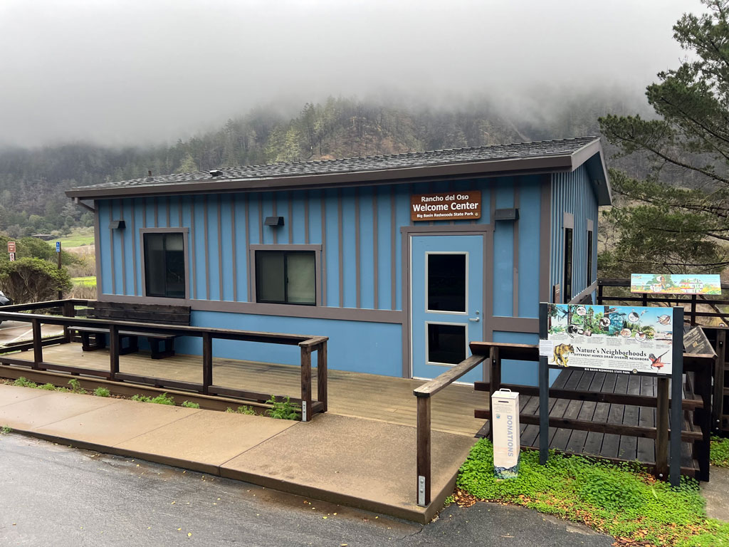 Welcome Center exterior, a blue mobile building in a natural setting of hills and brush.